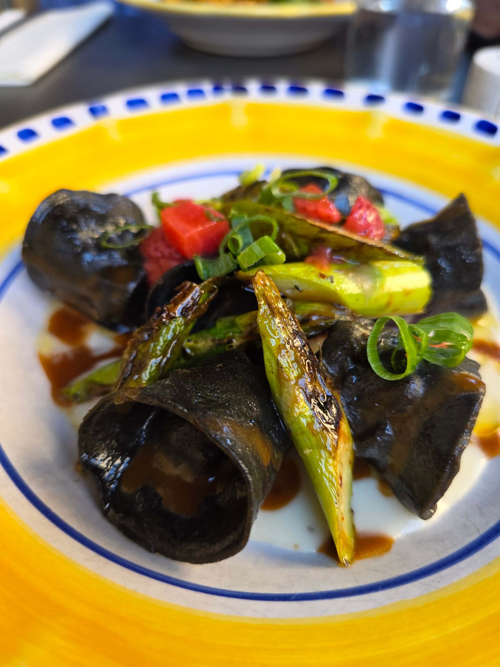 Cappellacci al Nero – tiefschwarz gefärbt mit Sepia – sind gefüllt und werden mit Garnelen, Bisque, grünem Spargel und einem Hauch Erdbeerchutney