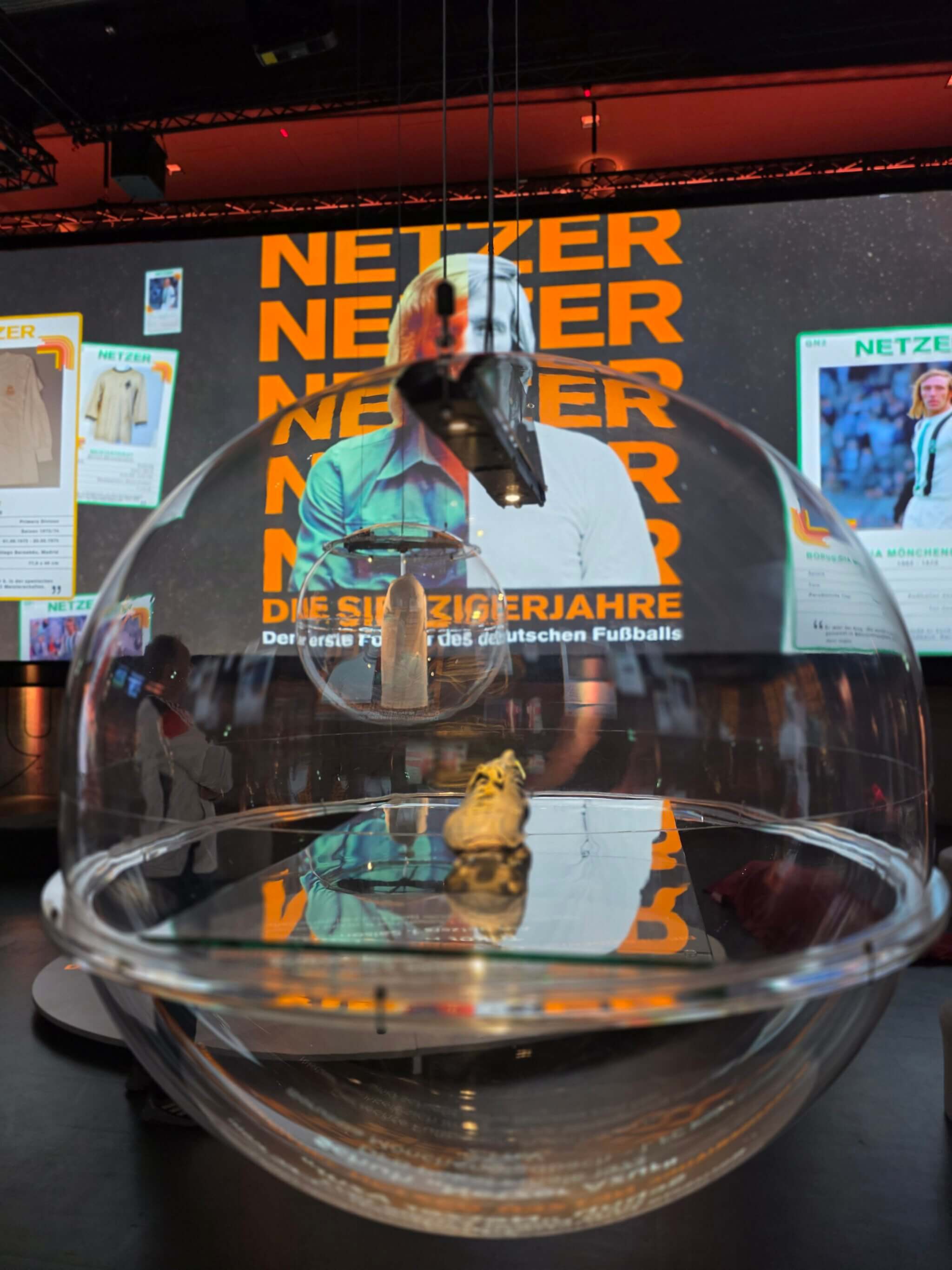 Multimediale Installation zur Karriere von Günter Netzer in der Sonderausstellung des Deutschen Fußballmuseums: Fußballschuh in Plastikvitrine von der Decke heruntergelassen