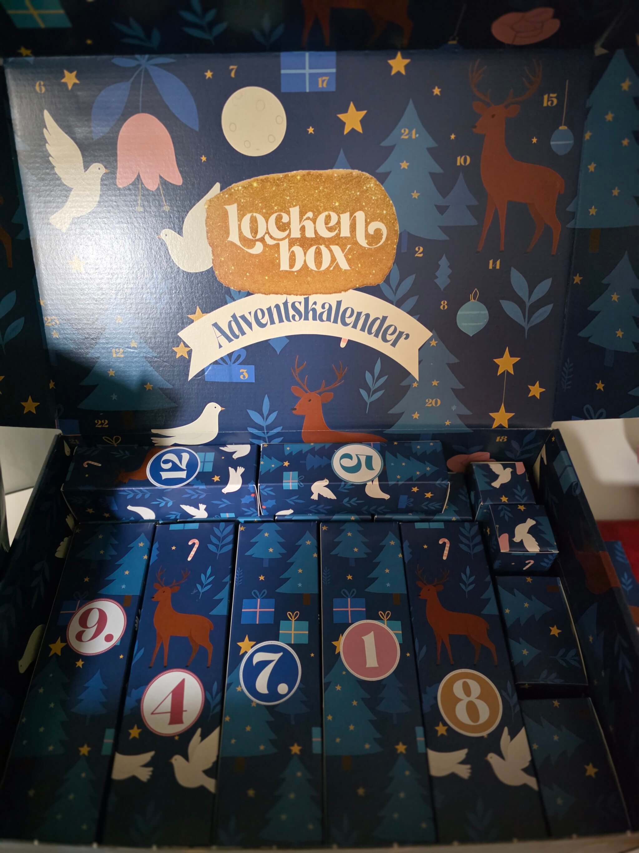 Geöffneter Lockenbox Adventskalender mit nummerierten Geschenkboxen und weihnachtlichem Design